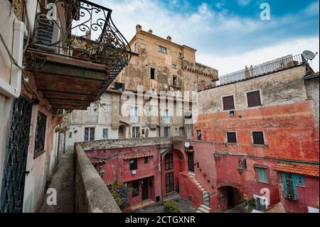 Ein kleiner Platz im alten Dorf San Felice Circeo (Latina, Italien), Blick von einem erhöhten Gehweg. Farbige Häuser. Lokale Architektur... Stockfoto