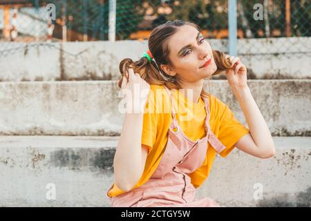 Porträt eines jungen, blonden Mädchens mit Zöpfen. Starke Make-up Stockfoto