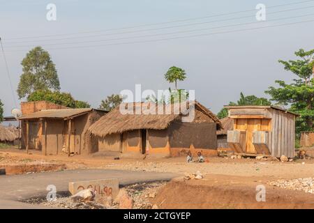 Kapapi / Uganda - Februar 26 2020: Zwei ugandische Kinder in zerlumpter Kleidung spielen vor ihren Häusern. Stockfoto