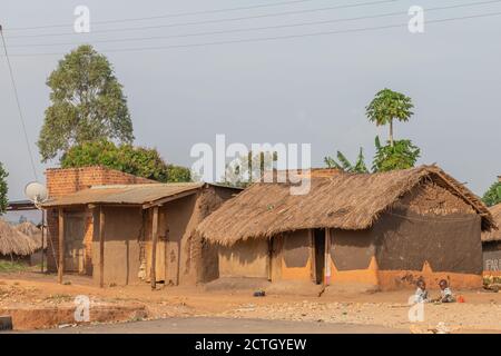 Kapapi / Uganda - Februar 26 2020: Zwei ugandische Kinder in zerlumpter Kleidung spielen vor ihren Häusern. Stockfoto