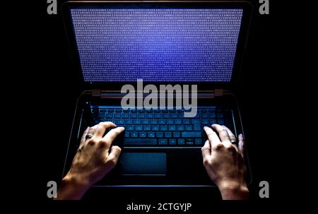 Hacker auf dem Laptop bei der Arbeit Stockfoto