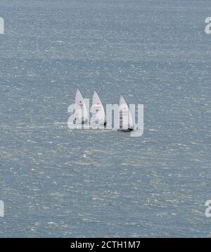 Portland Harbour, Vereinigtes Königreich - 3. Juli 2020: High Angle Luftportrait Aufnahme von drei Laser Klasse Segelsport Schlauchboote in Portland Harbo Stockfoto