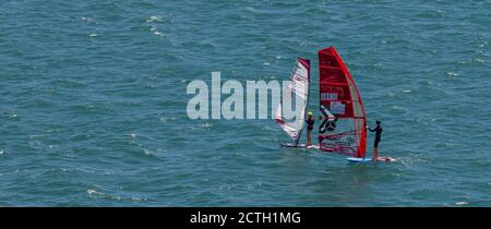 Portland Harbour, Großbritannien - 2. Juli 2020: High Angle Panorama Aufnahme von zwei Segelbrettern mit professionellen Surfern auf ihnen in Portland har Stockfoto