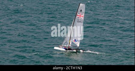 Portland Harbour, Vereinigtes Königreich - 2. Juli 2020: High Angle Panorama Aufnahme des Rennkatamarans des British Sailing Teams. Zwei Matrosen darauf w Stockfoto