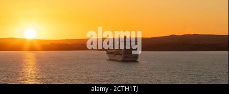 Weymouth Bay, Vereinigtes Königreich - 6. Juli 2020: Wunderschöne Panoramabild des P&O Kreuzfahrtschiffes Ventura, das bei Sonnenuntergang in der Weymouth Bay vor Anker liegt Stockfoto