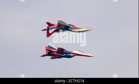 Barnaul, Russland - 19. September 2020: Nahaufnahme von Strizhi MiG-29 Kampfflugzeugen, die symmetrisch mit einem der fliegenden Kampfflugzeuge fliegen Stockfoto