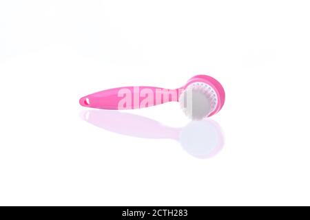 Rosa Reinigungsbürste für die Gesichtsreinigung auf weißem Hintergrund. Gesichtsmassage, Hautpflegemittel Stockfoto