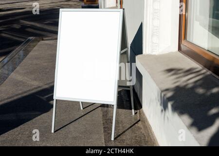 Schild auf der Straße. Abgewinkelter leerer Menütafel-Ständer. Restaurant Bürgersteig weißen Schild. Freistehende A-Rahmen Werbetafel in der Nähe von Outdoor-Café Stockfoto