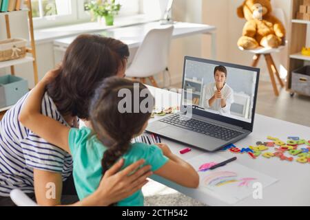 Mutter und Tochter kommunizieren online mit jungen Frau Arzt auf Notebook Stockfoto