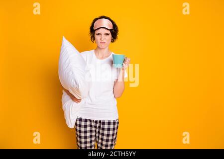 Portrait von ihr sie schön attraktiv schöne unzufrieden braunhaarige Mädchen Halten in den Händen weißes Kissen trinken warme Milch Ekel isoliert Hell Stockfoto