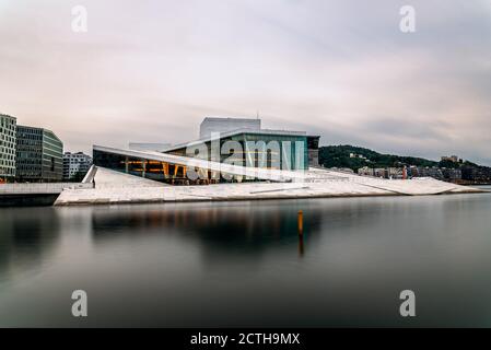 Oslo, Norwegen - 10. August 2019: Außenansicht des Opernhauses in Oslo. Langzeitbelichtung bei Dämmerung. Neues, modernes Gebäude, entworfen von Snohetta Architekten. IT i Stockfoto