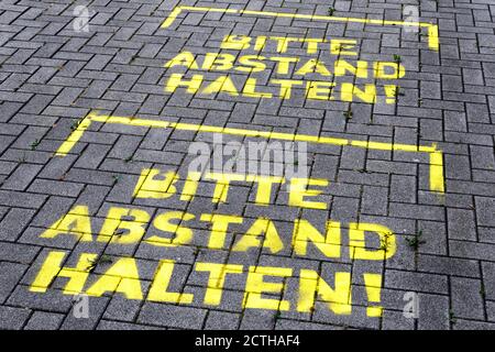 Dortmund, 23. September 2020: BITTE ABSTAND halten! Markierungen auf dem Boden vor dem bvb09 Fanshop im Signal Iduna Park (Westfalenstadion) in Dortmund --- Dortmund, 23.09.2020: > BITTE STEHEN HALTEN!< Markierungen auf dem Boden vor dem Fanshop des bvb09 am Signal Iduna Park (Westfalenstadion) in Dortmund Stockfoto