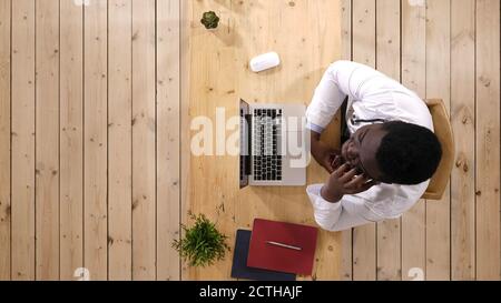 Arzt spricht auf Smartphone, sitzt im Büro. Stockfoto