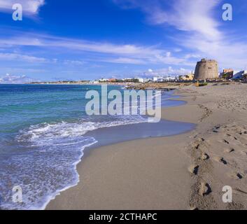 Strand von Torre Mozza in Salento, Apulien (Italien). Der ruinierte Wachturm blickt auf den langen Strand von Torre Mozza mit feinem Sand, der vom klaren Wasser umspült wird. Stockfoto