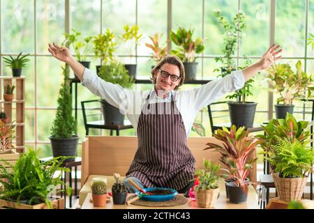 Ein Mann oder Großvater mit genießt Gartenarbeit für den Baum zu Hause nach dem Ruhestand. Stockfoto