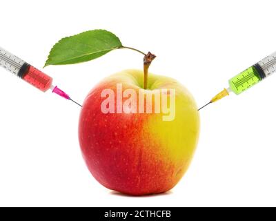 Spritzen in einem Apfel stecken. Konzept der genetischen Veränderung von Früchten und künstliche Reifung Stockfoto
