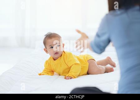 Happy Baby gehen auf caepet zu Hause. Kind und Elternschaft Konzept, Mutter spielt mit kleinen Baby zu Hause Stockfoto