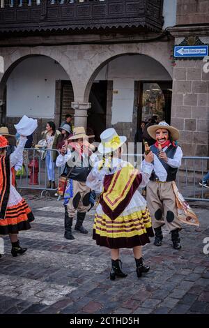 Männer und Frauen in Kostümen und Masken tanzen in einer Prozession während des Sonnenfestes Inti Raymi'rata über die Wintersonnenwende, Cusco, Peru Stockfoto