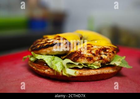 Köstliche Chicken Burger Kochen.Hamburger gekocht auf Grill in Fast Food Restaurant Küche zum Abendessen. Gegrilltes Geflügelfleisch, Salat auf Cru serviert Stockfoto