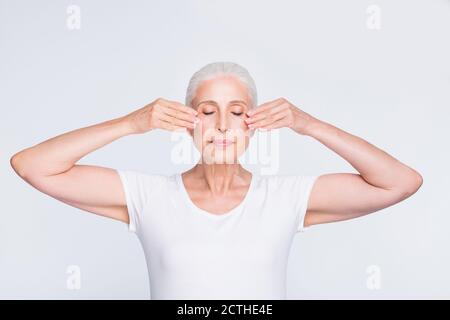 Porträt von ihr sie schön aussehende attraktiv gepflegt ruhig friedlich grauhaarig lady berühren Glättung perfekte saubere klare Haut isoliert über Stockfoto