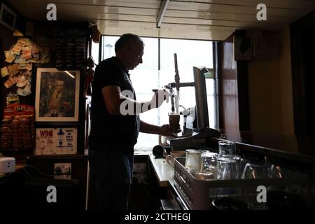 John Frances Carty zieht zum ersten Mal ein Pint, seit Lock Down in seinem nassen Pub The Maypole Bar in Holywood, Nordirland, aufgehoben wurde, da Pubs, die kein Essen servieren, am Mittwoch in ganz Nordirland wieder eröffnet werden, trotz frischer Covid-19 Einschränkungen. Stockfoto