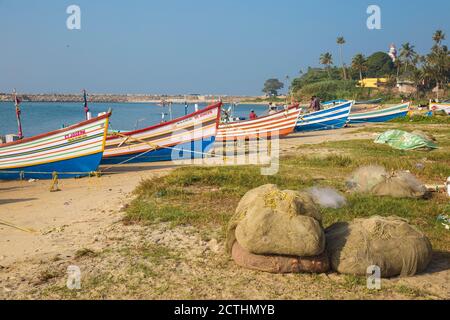 Indien, Kerala, Kollam, Fischerboote am Strand mit Tangasseri Leuchtturm im Hintergrund Stockfoto