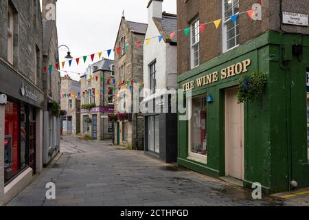 Blick auf die Geschäfte entlang der verlassenen Commercial Street in der Altstadt von Lerwick, Shetland Isles, Schottland, Großbritannien Stockfoto