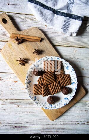 Leckere Schokoladenkekse und Pralinen auf einer Holzplatte Ein Hintergrund Stockfoto