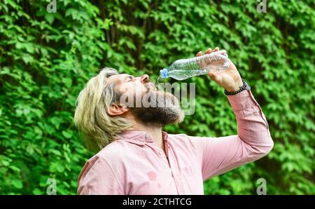 Die Flasche ablassen. Tägliche Wasseraufnahme. Durstige männliche Modell genießen erfrischende Getränk. Gesunde Ernährung und Trinken. Trinkwasser. Schöner Mann, der frisches Wasser aus der Flasche trinkt. Morgendliche Routine. Stockfoto