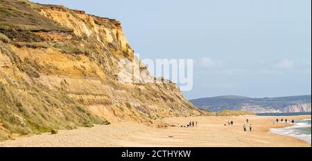 Blick auf EINE Sandsteinklippe von Hengistbury Head und Strand mit Menschen zu Fuß, Christchurch UK Stockfoto
