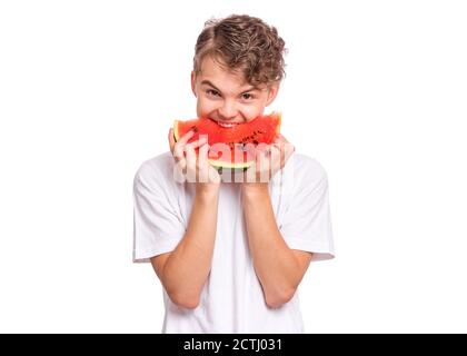 Portrait von teen junge Essen reif saftig Wassermelone und lächelnd. Netter junger Teenager mit gesunder Wassermelone in Scheiben, isoliert auf weißem Hintergrund. Stockfoto