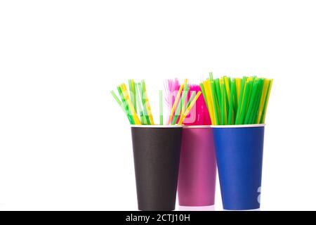 Drei Einwegbecher mit mehrfarbigen Plastikhalmen. Verbot von Einweg-Kunststoff Stockfoto