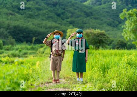 Asian Scout trägt eine Maske und zeigen Respekt, neue Normalität Stockfoto