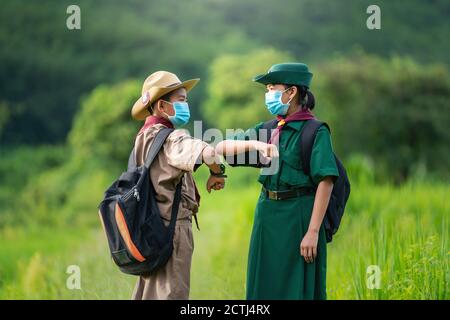 Asian Scout trägt eine Maske und zeigt eine neue Normalität Begrüßung Stockfoto