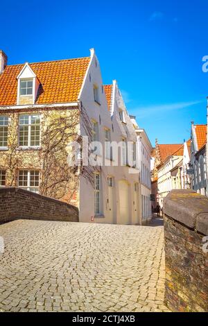 Brügge, Belgische Straße und Brücke, farbenfrohe traditionelle Häuser vor blauem Himmel in der beliebten belgischen Destination Brügge Stockfoto