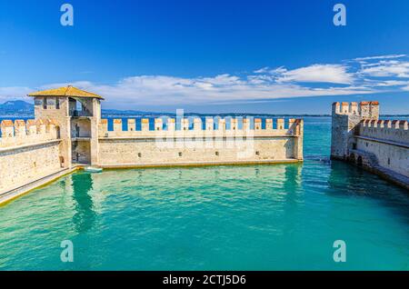 Sirmione, Italien, 11. September 2019: Kleiner befestigter Hafen mit türkisfarbenem Wasser, Scaligero Burg Castello Festung, Stadt am Gardasee, mittelalterliche Burg mit Steintürmen und Backsteinmauern, Lombardei Stockfoto