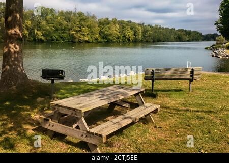 Bank und Picknicktisch am Ufer des Seneca River in Liverpool, New York Stockfoto