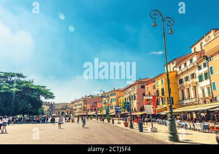 Verona, Italien, 12. September 2019: Piazza Bra Platz im historischen Stadtzentrum mit Reihe von alten bunten bunten Gebäuden Cafés und Restaurants und Wandertouristen Menschen, Region Venetien Stockfoto