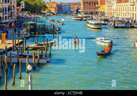 Venedig, Italien, 13. September 2019: Canale Grande Wasserstraße mit Booten und Vaporettos Segeln, Yachten in der Nähe von hölzernen Pier, Gondoliere auf Gondeln in Canal Grande, Santa Croce Promenade, Region Venetien Stockfoto