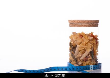 Italienische Pasta in korkierten Glas eingewickelt in blauem Maßband. Diät-Konzept Stockfoto