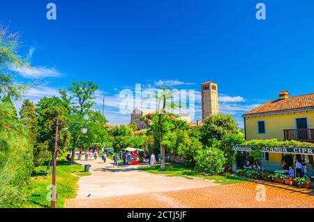 Torcello, Italien, 14. September 2019: Insel mit grünen Bäumen und Sträuchern, Kathedrale Santa Maria Assunta Turm und Kirche Santa Fosca Gebäude. Blauer Himmel Hintergrund. Lagune Von Venedig, Region Venetien Stockfoto