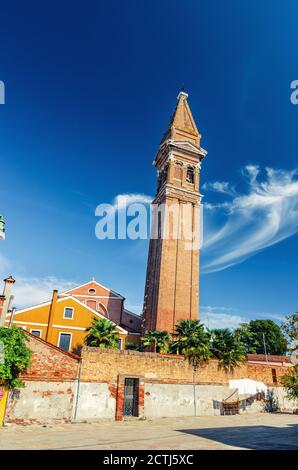 Römisch-katholische Kirche San Martino auf der Insel Burano mit Glockenturm aus Backstein, blauer Himmel im sonnigen Sommertag, Provinz Venedig, Region Venetien, Norditalien. Burano Postkarte Stockfoto