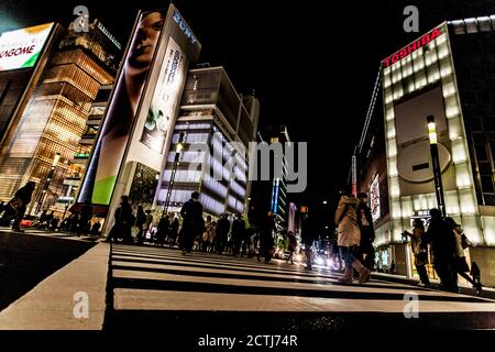 Tokyo, Japan - 14. Januar 2010: Fußgänger überqueren der Straße im Herzen von Ginza in Tokio. Ginza Kreuzung bei Nacht. Verschwommene Bewegung. Stockfoto