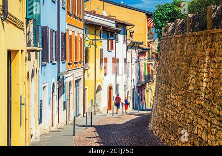 Typische schmale Straße in der Altstadt von Desenzano del Garda Stadt mit Kopfsteinpflaster Straße und traditionellen bunten Gebäuden mit Fensterläden, Lombardei, Norditalien Stockfoto