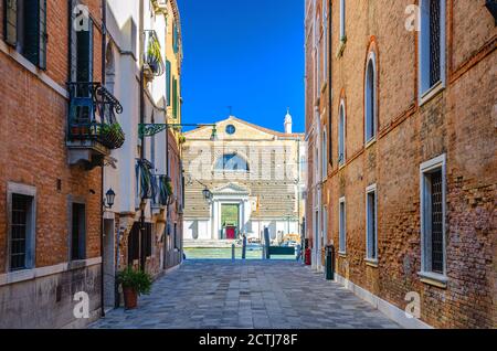 Venedig, Italien, 13. September 2019: Enge Straße zwischen alten Gebäuden, die zum Canal Grande Wasserweg in der Altstadt führen, Kirche Chiesa di San Marcuola und blauer Himmel im Sommer Stockfoto