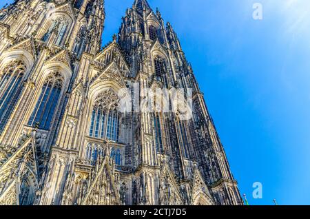 Fassade des Kölner Doms Römisch-Katholische Kirche St. Peter gotischer Baustil mit Türmen im historischen Stadtzentrum, blauer Himmel an sonnigen Tagen, Nordrhein-Westfalen, Deutschland Stockfoto