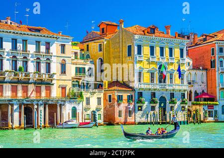Venedig, Italien, 13. September 2019: Gondoliere und Touristen auf Gondel traditionelle Boot Segeln auf dem Wasser des Canal Grande Wasserstraße mit venezianischer Architektur typischen bunten Gebäuden Hintergrund Stockfoto