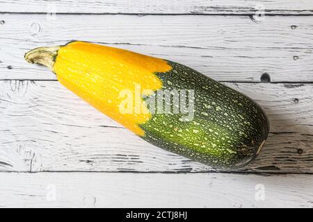 Frische Zucchini-Squashes auf Holzhintergrund. Hässliche Zucchini in zwei Farben gelb und grün. Stockfoto