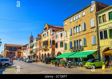 Chioggia, Italien, 16. September 2019: Reihe von bunten bunten Gebäuden auf der Hauptstraße Corso del Popolo in Chioggia historischen Zentrum, blauer Himmel Hintergrund im Sommer, Region Venetien Stockfoto