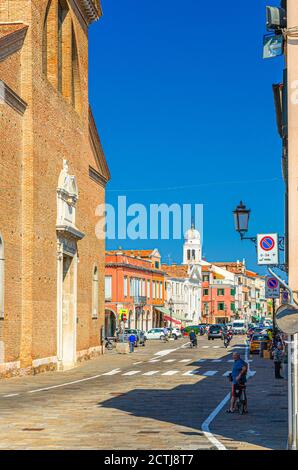 Chioggia, Italien, 16. September 2019: Kathedrale Santa Maria Assunta katholische Kirche und Reihe von bunten bunten Gebäuden im historischen Stadtzentrum, blauer Himmel am Sommertag, Region Venetien Stockfoto